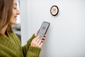 person-setting-thermostat-by-using-a-smartphone